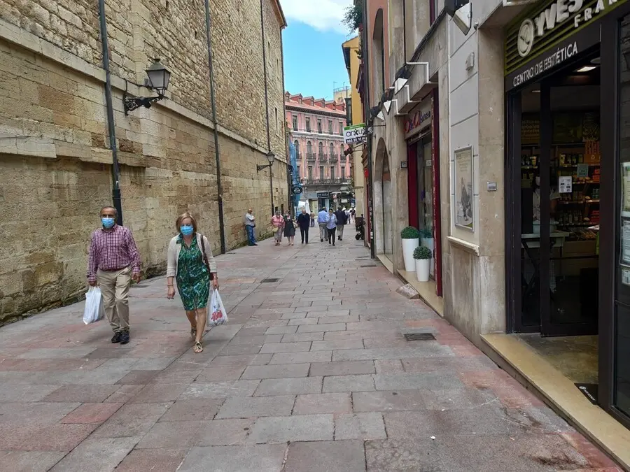 Personas con mascarilla en las calles de Oviedo y terrazas de hosteler&iacute;a.
