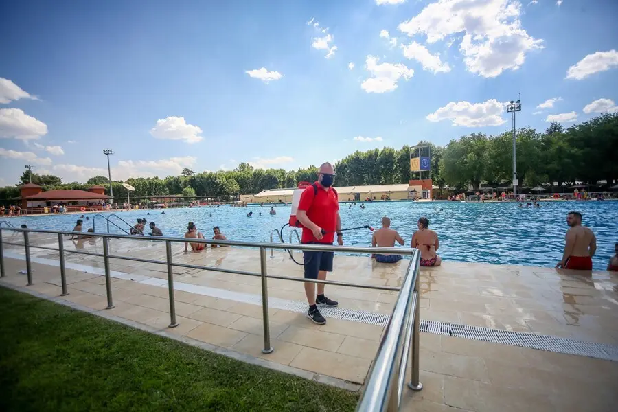 Un hombre desinfecta las zonas de la piscina del Parque Deportivo de Puerta de Hierro, el primer d&iacute;a de apertura de las piscinas para la temporada de verano, a 26 de junio de 2021, en Madrid (Espa&ntilde;a). 