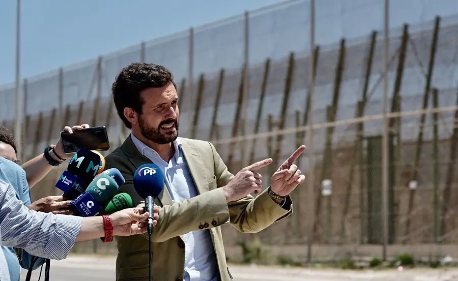 El l&iacute;der del PP, Pablo Casado, atiende a los medios junto a la valla de Melilla situada entre la frontera de Beni Ensar y la de Barrio Chino. En Melilla, a 14 de julio de 2021.