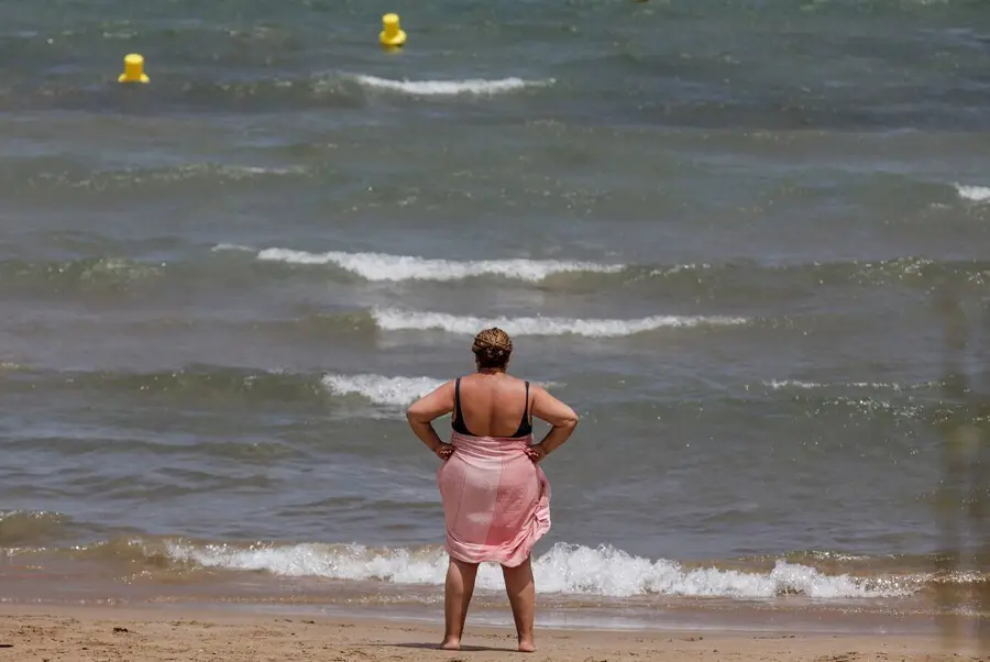 Una mujer en la Playa de la Malvarrosa (Valencia) el pasado 12 de julio, d&iacute;a con alerta roja por altas temperaturas