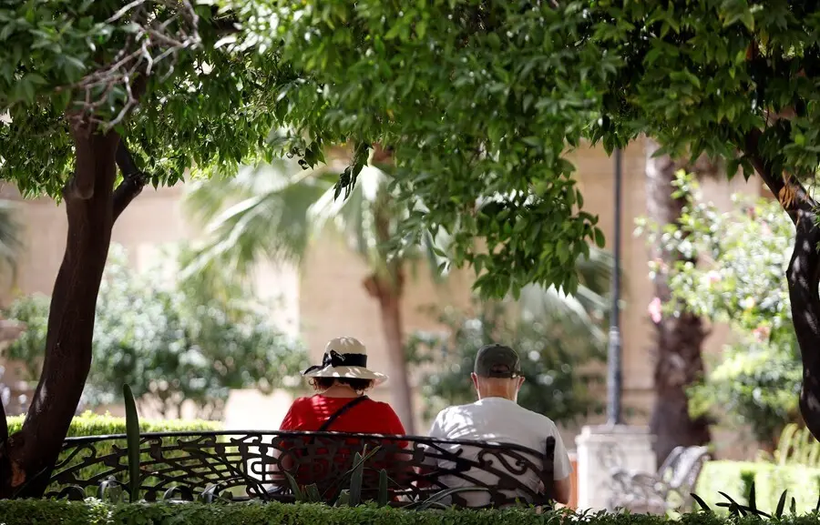Varias personas intentan protegerse del calor en el d&iacute;a donde la capital andaluza se encuentra  en  aviso naranja por temperaturas que superar&aacute;n los 40 grados en algunos puntos de la capital y la provincia a 12 de julio del 2021 en M&aacute;laga (Andaluc&iacute;a). Se 