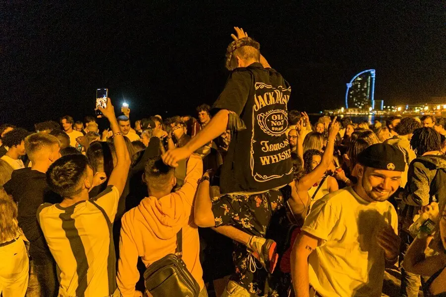 Varios grupos de j&oacute;venes en la playa de la Barceloneta horas antes de que entre en vigor el toque de queda en Catalunya