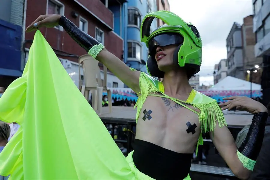 Integrantes de la comunidad LGTBI y del colectivo Toloposungo se manifiestan el 16 de julio de 2021 en el centro de Bogot&aacute; (Colombia). Con un casco de Polic&iacute;a, el pecho descubierto y falda de volantes verde fosforito, una joven detiene el tr&aacute;fico en el centro de Bogot&aacute;, mientras que sus compa&ntilde;eras trans y travestis bailan "vogue" en mitad de la calle de forma festiva, contra la violencia policial y reivindicando a las que ya no est&aacute;n. EFE/ Carlos Ortega