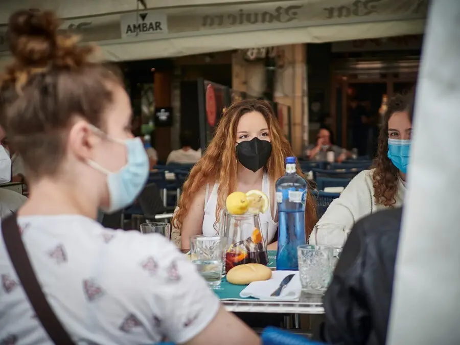 Un grupo de j&oacute;venes come en la terraza de un restaurante.