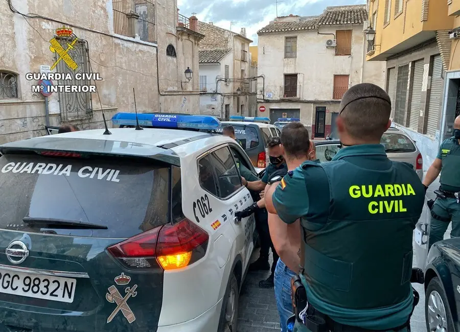 Agentes de la Guardia Civil trasladan a uno de los detenidos