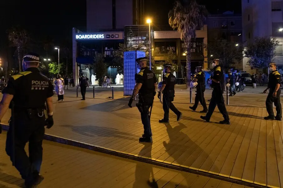 Agentes de la Guardia Urbana forman una l&iacute;nea tras desalojar la playa de la Barceloneta la noche en la que entra en vigor el toque de queda en Catalu&ntilde;a, a 16 de julio de 2021, en Barcelona, Catalunya (Espa&ntilde;a). El Tribunal Superior de Justicia de Catalu&ntilde;a 