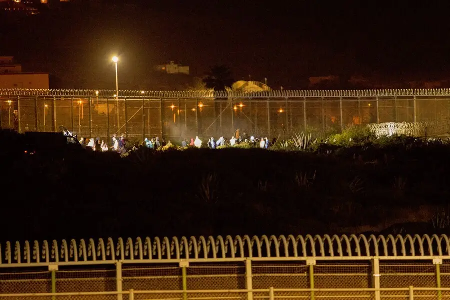 Archivo - Varios marroqu&iacute;es intentan llegar a suelo espa&ntilde;ol desde la frontera que separa Melilla y Marruecos en una imagen de archivo.