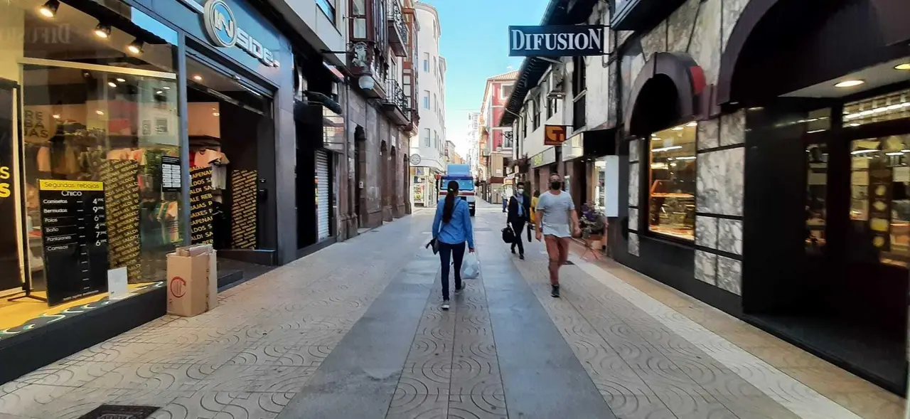 Varias personas con mascarilla por la calle Consolaci&oacute;n de Torrelavega. / S. D&iacute;az