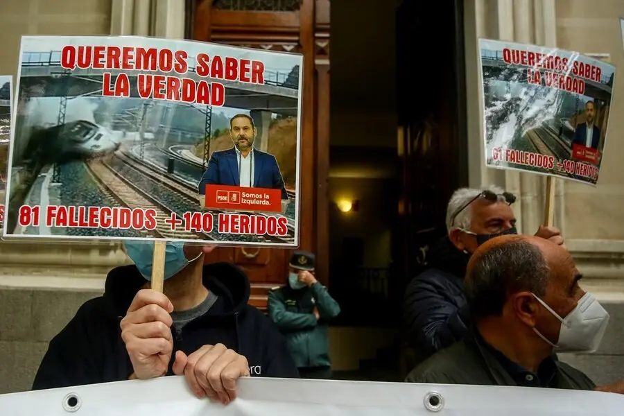 Archivo - Varias v&iacute;ctimas del accidente ferroviario del Alvia se concentran con una pancarta y carteles en los que se lee: "Queremos saber la verdad, 81 fallecidos + 140 heridos".