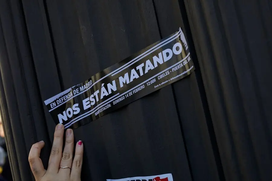 Archivo - Una persona sujeta un cartel en el que se lee: `Nos est&aacute;n matando&acute; 