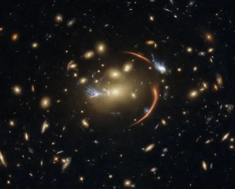 La distante galaxia MRG-M0138 w, captada por el Hubble con una lente gravitacional