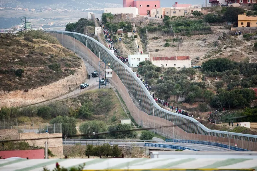 Archivo - Varios marroqu&iacute;es intentan llegar a suelo espa&ntilde;ol desde la frontera que separa Melilla y Marruecos, a 21 de mayo de 2021, en Marruecos.