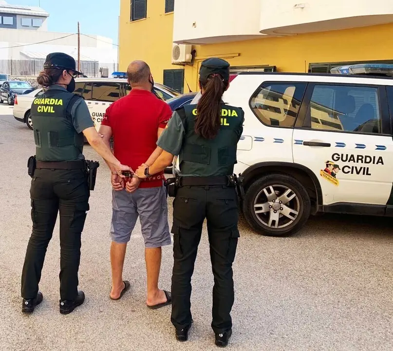 Dos agentes de la Guardia Civil junto al detenido.