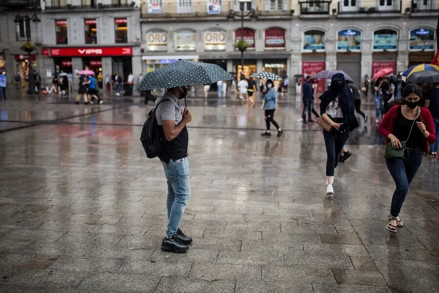 Archivo - Ciudadanos se resguardan de la lluvia a 5 de junio de 2021, en Madrid (Espa&ntilde;a)