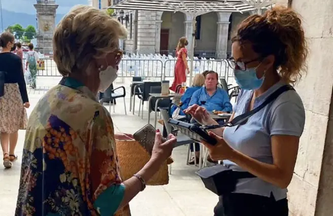 Una mujer pide un aperitivo en la entrada de un establecimiento en la plaza Porticada de Santander. / Hardy