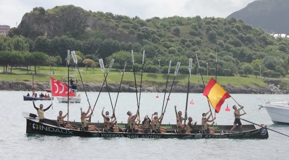 Los remeros de Getaria, con la bandera que les acreditaba como campeones de Espa&ntilde;a y con la que conmemoraba los quinientos a&ntilde;os desde la primera vuelta al Mundo de su paisano Elcano.