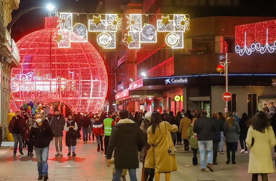 Archivo - Transe&uacute;ntes pasean bajo las luces navide&ntilde;as, en Vigo, en diciembre de 2020.