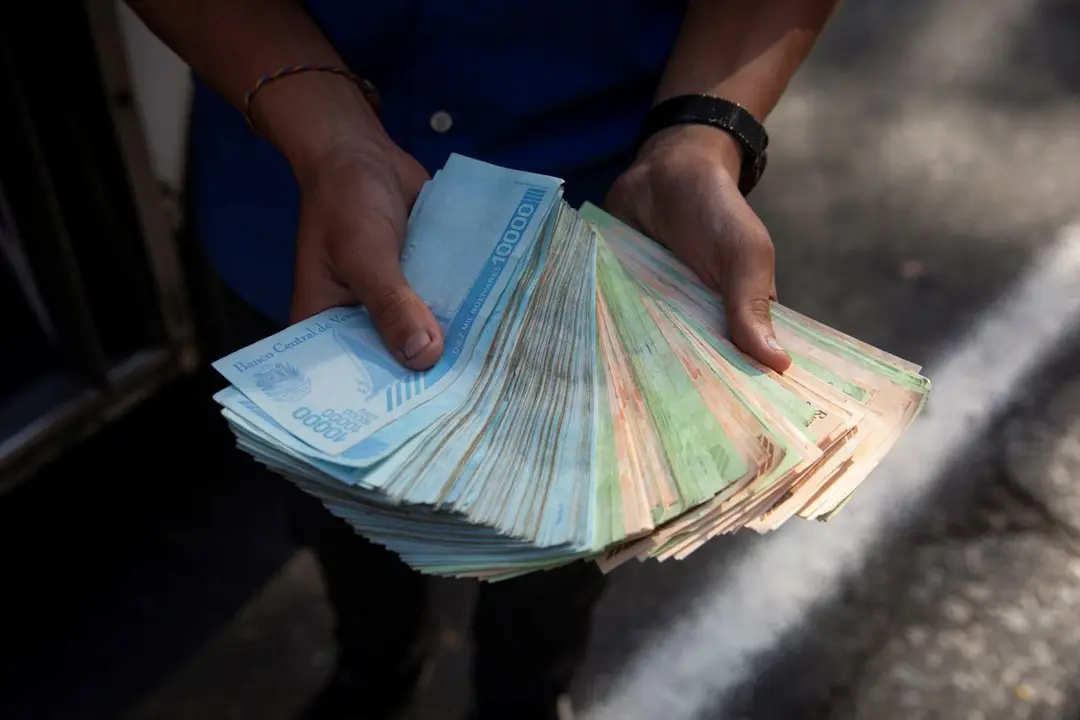 Un transportista muestra un fajo de bol&iacute;vares, el pasado 12 de marzo de 2021, en Caracas. / RAYNER PE&Ntilde;A R. / EFE