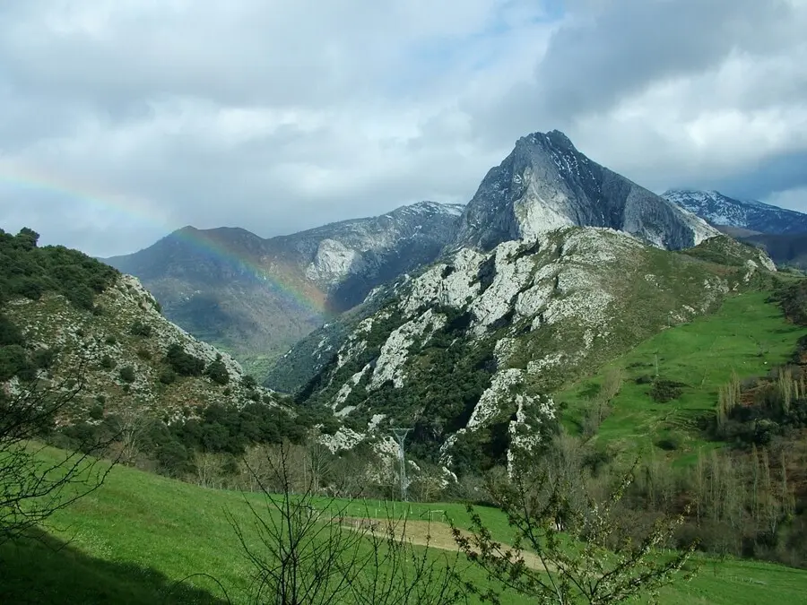 Archivo - Paisaje con monta&ntilde;as, nubes y arco iris