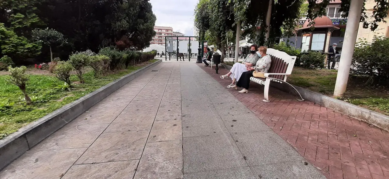 Dos personas con mascarilla sentadas en la Plaza Jos&eacute; Mar&iacute;a Gonz&aacute;lez Trevilla. /  S. D&Iacute;AZ