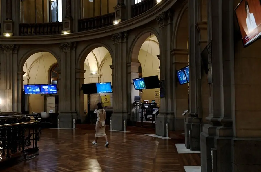 Archivo - Una mujer camina por el interior de la Bolsa de Madrid