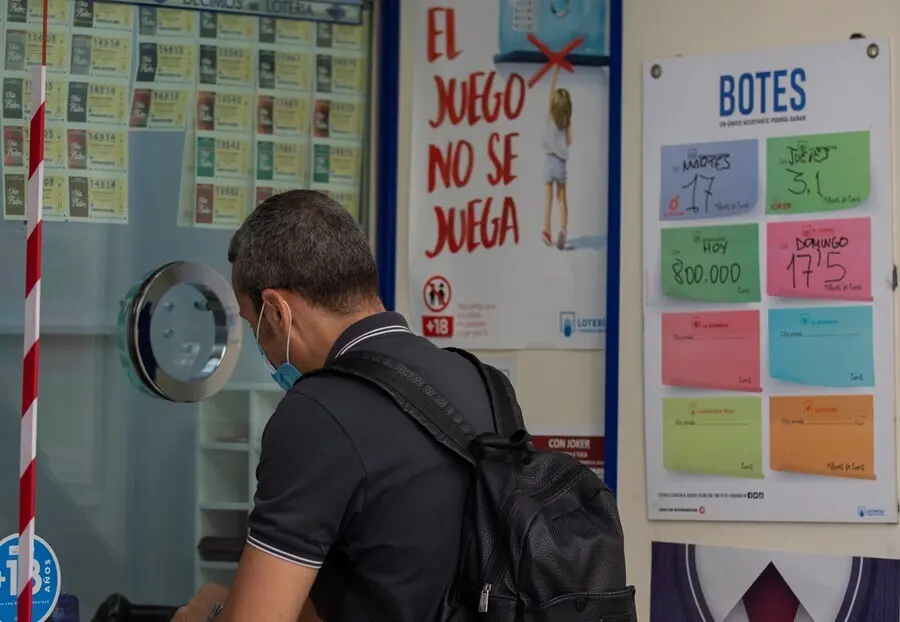 Archivo - Una persona compra loter&iacute;a en una administraci&oacute;n