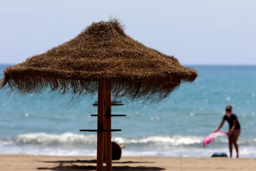 Archivo - Paseantes disfrutan de la playa de Sacaba en la barriada de Huel&iacute;n, en M&aacute;laga 