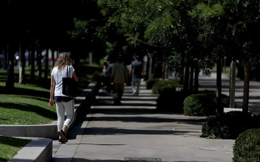 Archivo - Algunas personas caminando por las calles del Paseo de Recoletos de Madrid en plena ola de calor.