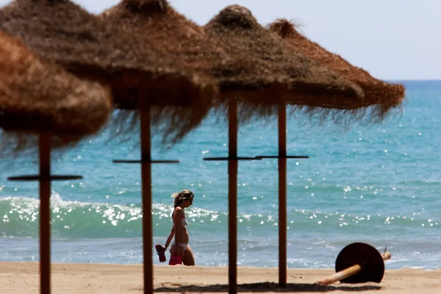 Archivo - Paseantes disfrutan de la playa de Sacaba en la barriada de Huel&iacute;n