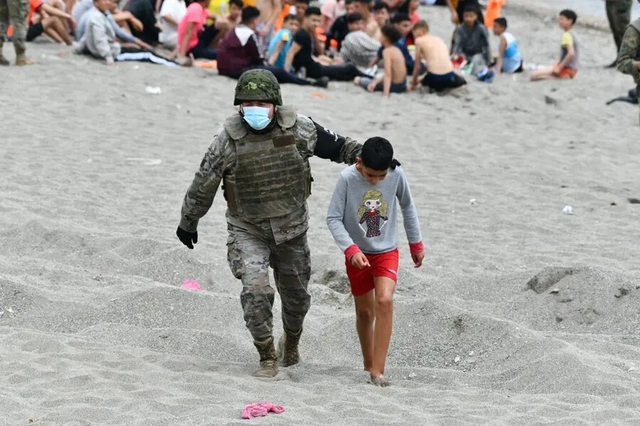 Archivo - Un militar del ej&eacute;rcito espa&ntilde;ol acompa&ntilde;a a un ni&ntilde;o en Ceuta