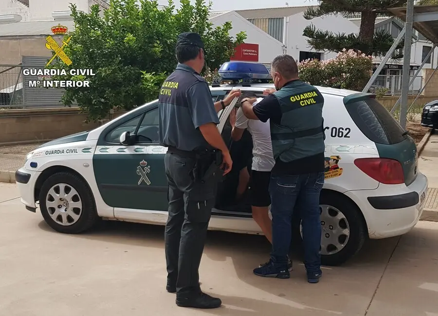 El detenido es introducido en el coche policial