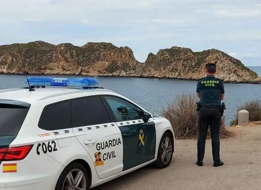 Coche patrulla y agente de la Guardia Civil
