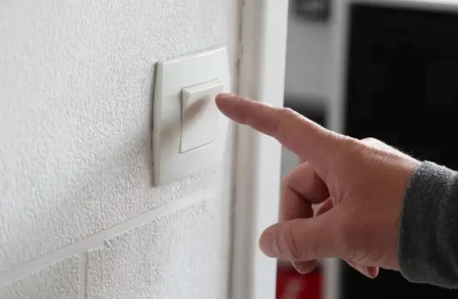 Una persona se dispone a apagar la luz de su casa.