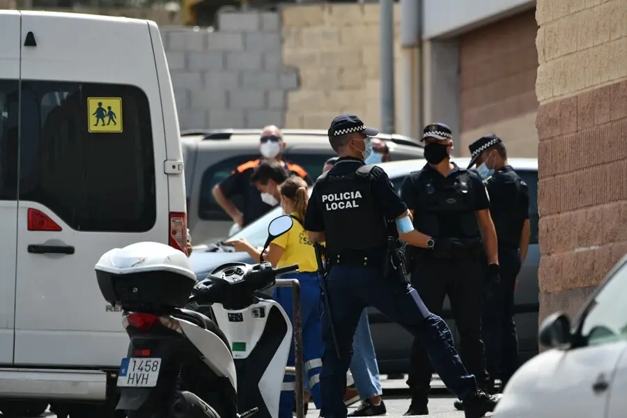 Varios agentes y veh&iacute;culos de la Polic&iacute;a Local de Ceuta acompa&ntilde;an a menores no acompa&ntilde;ados hacia una furgoneta, en las inmediaciones del Polideportivo Santa Amelia, donde fueron acogidos 250 de los 800 menores que llegaron a Ceuta el pasado mes de mayo
