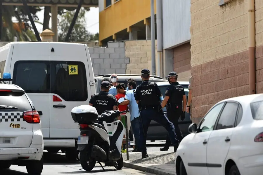 Varios agentes y veh&iacute;culos de la Polic&iacute;a Local de Ceuta acompa&ntilde;an a menores no acompa&ntilde;ados hacia una furgoneta, en las inmediaciones del Polideportivo Santa Amelia, donde fueron acogidos 250 de los 800 menores que llegaron a Ceuta el pasado mes de mayo,