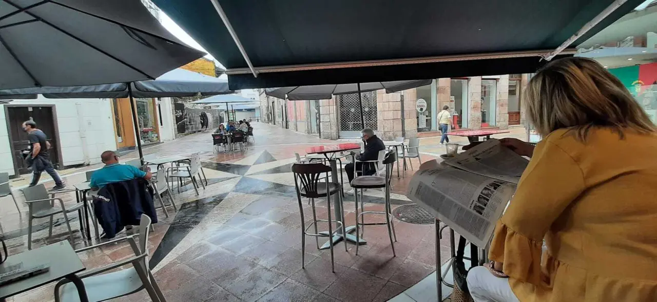 Una persona ojea el diario ALERTA en una cafeter&iacute;a de la calle Escalante de Torrelavega. / S. D&iacute;az