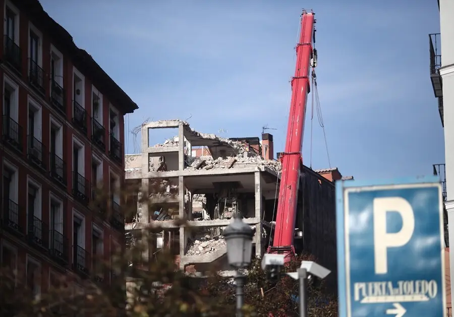 Archivo - Una gr&uacute;a trabaja en la demolici&oacute;n de la planta sexta del edificio de la calle Toledo 98.