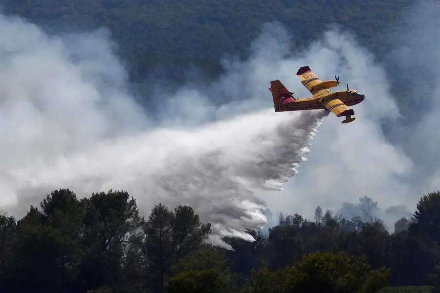 Un avi&oacute;n de extinci&oacute;n de incendios lanza agua en el lugar de un incendio forestal en la localidad de Gonfaron, cerca de Saint-Tropez. EFE/EPA/GUILLAUME HORCAJUELO
