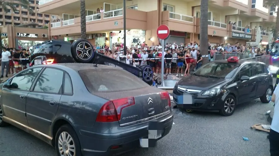 El coche implicado en el accidente en el que ha muerto un ciclista en el paseo mar&iacute;timo de Fuengirola, volcado en plena v&iacute;a ante la atenta mirada de ciudadanos