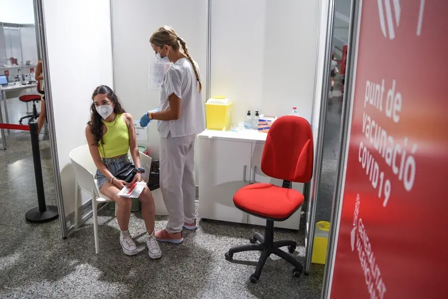 Una sanitaria vacuna a una adolescente con la primera dosis de la vacuna Moderna en la Ciudad de las Artes, a 16 de agosto de 2021, en Valencia, Comunidad Valenciana, (Espa&ntilde;a).