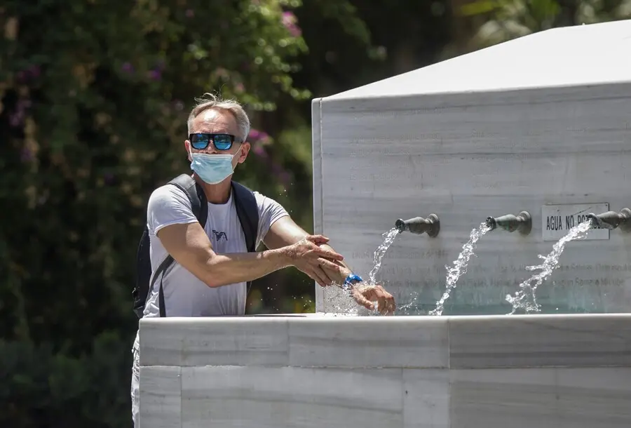 Archivo - Un hombre se refresca en una fuente durante la ola de calor africano que ha llegado este jueves a Espa&ntilde;a. En Sevilla (Andaluc&iacute;a, Espa&ntilde;a), a 30 de julio de 2020.