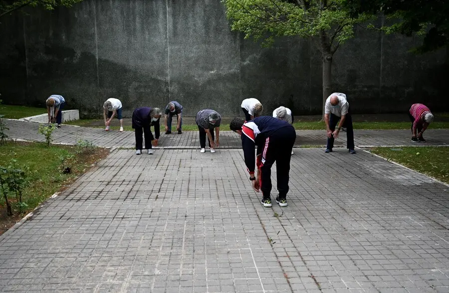 Archivo - Un grupo de ancianos realiza ejercicio en el jard&iacute;n de un centro de d&iacute;a de personas mayores 