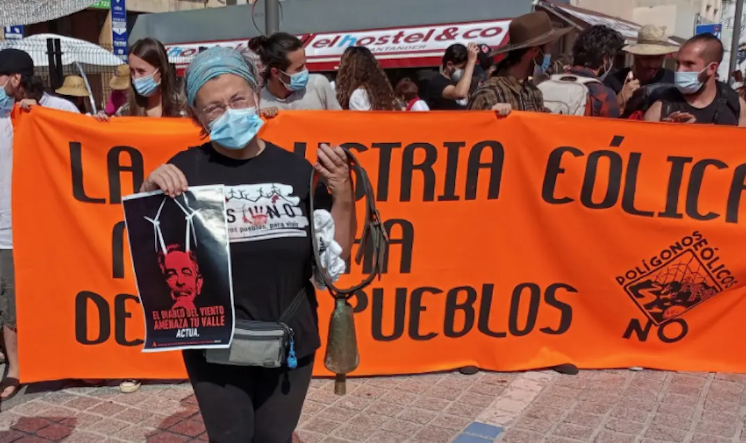 Una persona sostiene un cartel que dice: "El Diablo del viento amenaza tu valle' y sale la imagen de Revilla. / @DPasiegos