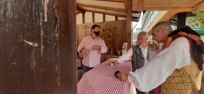 Dos personas disfrutan de un orujo en una de las casetas de la Feria del Hojaldre en Torrelavega. / S. D&iacute;az