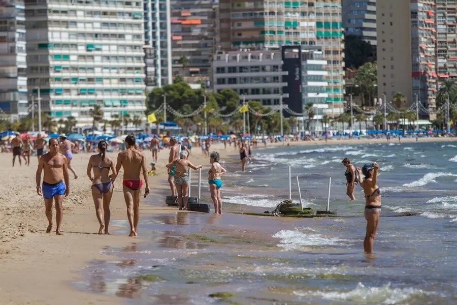 Archivo - Varias personas pasean por la Playa de Levante de Benidorm