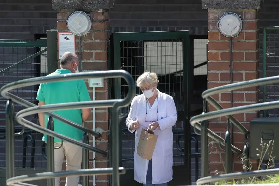 Una trabajadora atiende a un familiar en la puerta de la residencia de As G&aacute;ndaras de Lugo, en agosto de 2021.