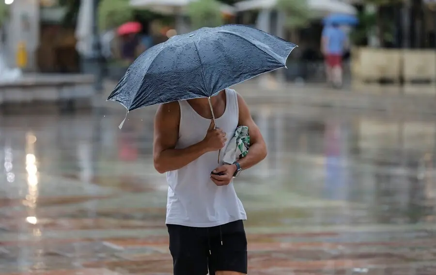 Una persona sostiene un paraguas mientras llueve, a 26 de julio de 2021, en Valencia, Comunidad Valenciana, (Espa&ntilde;a). 