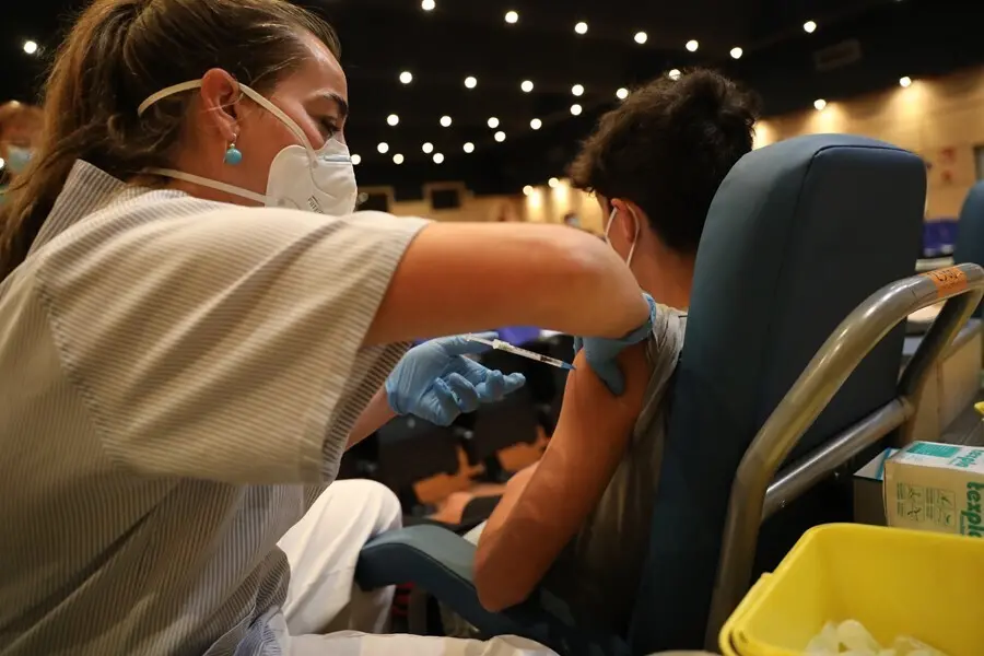 Una sanitaria vacuna a un menor  contra el coronavirus con una dosis de Pfizer