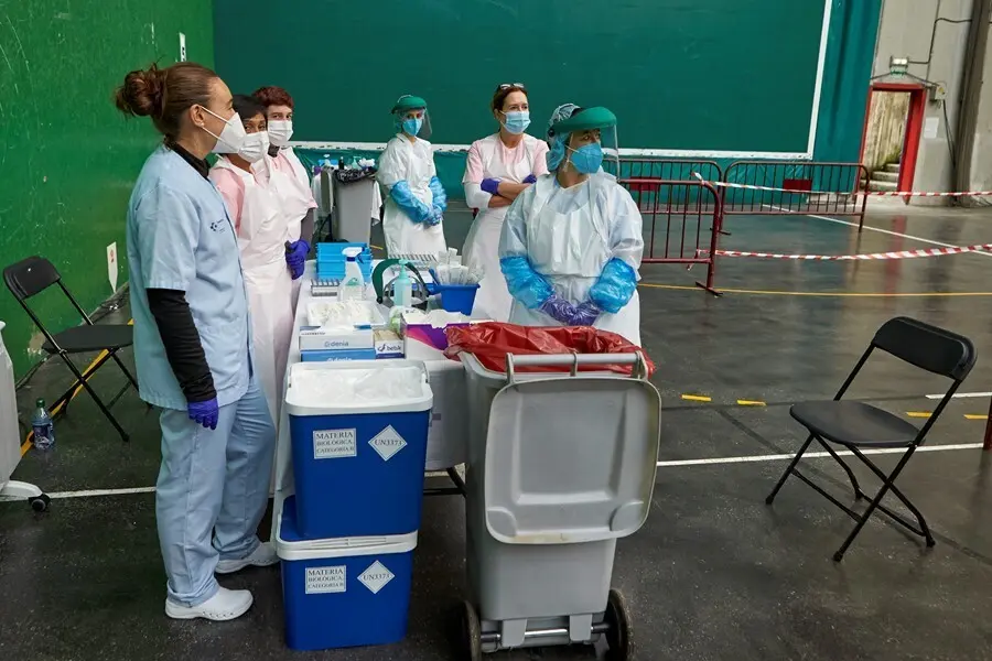 Archivo - Trabajadoras sanitarias esperan la llegada de personas en un dispositivo de extracci&oacute;n de pruebas PCR 