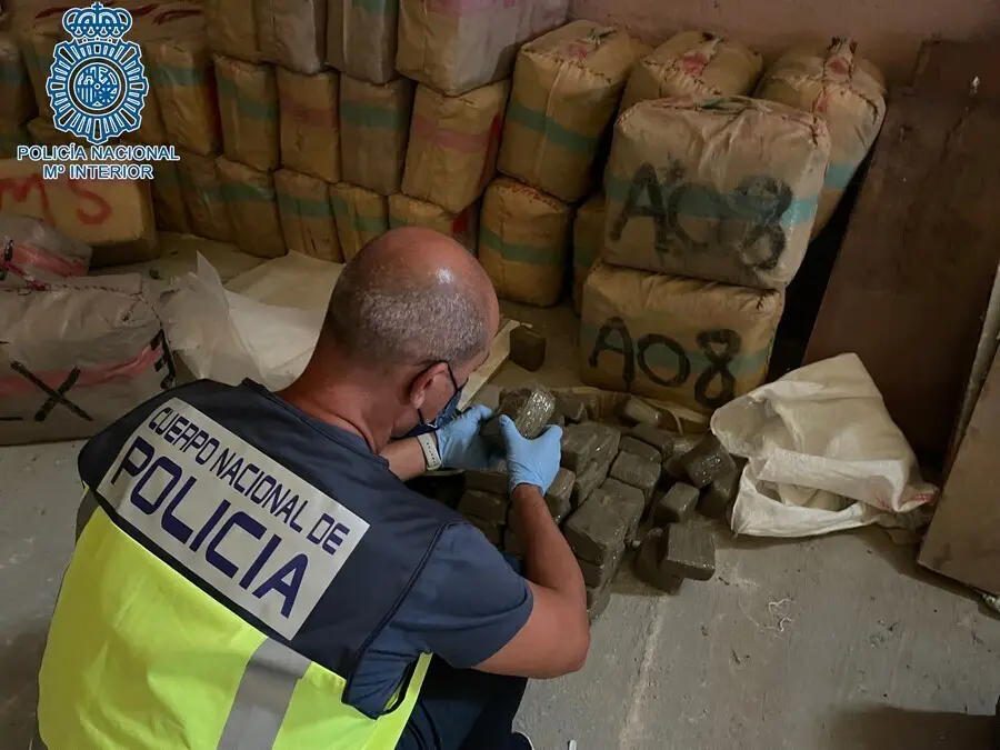 Un agente de la Polic&iacute;a comprueba el contenido de los fardos hallados en una nave de Dos Hermanas